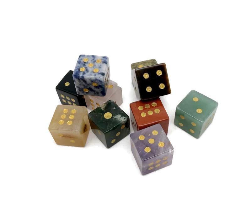 Polished gemstone crystal dice set with carved numbers, ideal for metaphysical use and gaming, by GemstoneGO.