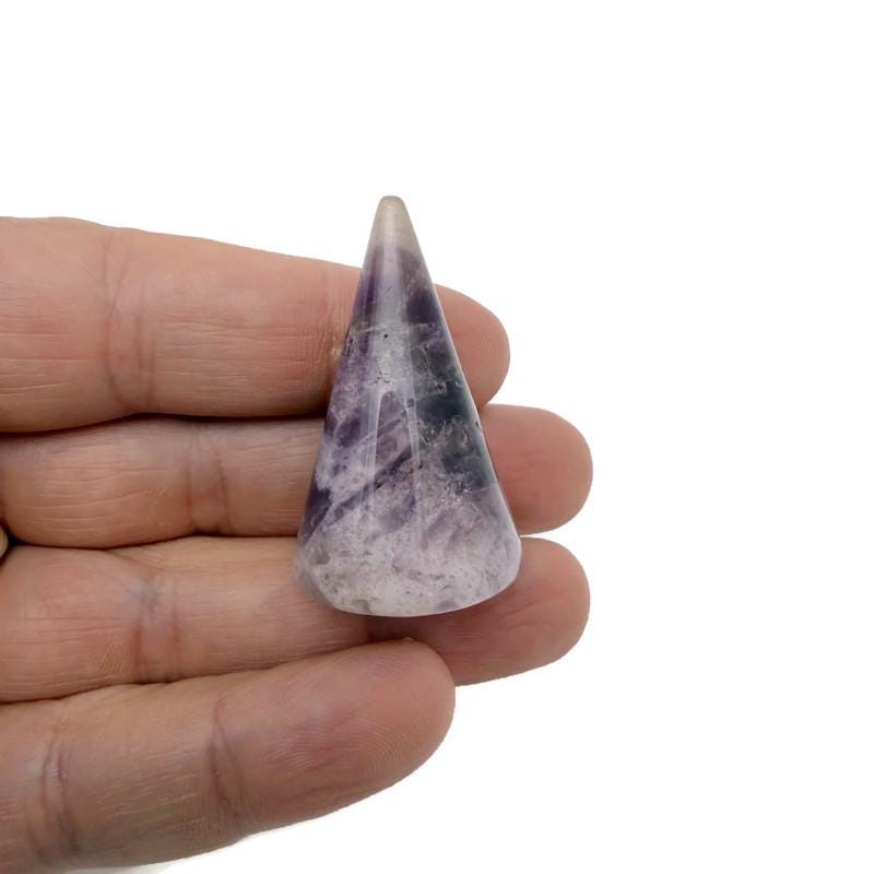 Carved gemstone cone ring holder displaying multiple rings, jewelry display stand by GemstoneGO for organizing and showcasing rings.