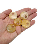 Yellow jade crystal donut pendant from GemstoneGO, 30mm Pi stone with a smooth, polished surface and vibrant yellow color.