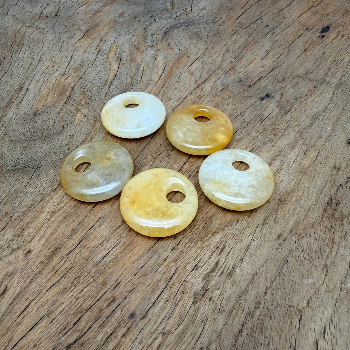 Yellow jade crystal donut pendant from GemstoneGO, 30mm Pi stone with a smooth, polished surface and vibrant yellow color.