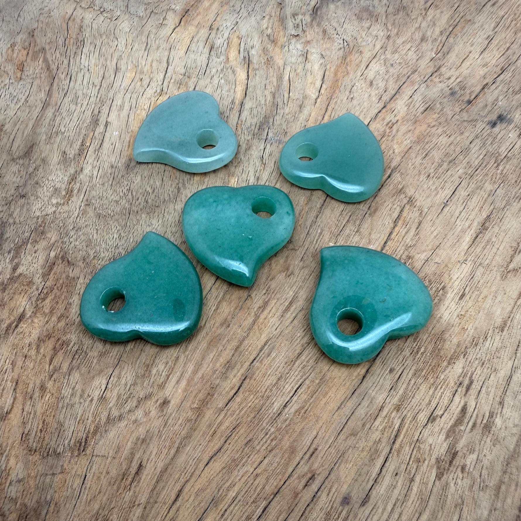 A 30mm Aventurine crystal heart with a hole, showcasing vibrant green gemstone with natural inclusions and smooth polished surface.