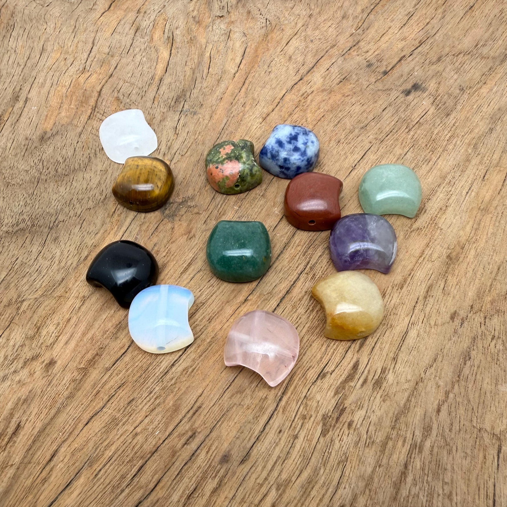 Assorted 16mm crystal moon beads from GemstoneGO for jewelry making, showcasing shiny, translucent moon-shaped gemstone beads.