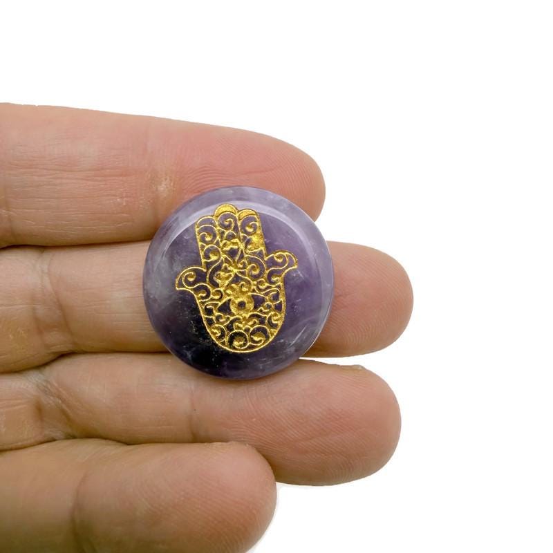 Engraved Hamsa Hand crystal from GemstoneGO, featuring intricate designs for protection, luck, and spiritual energy.