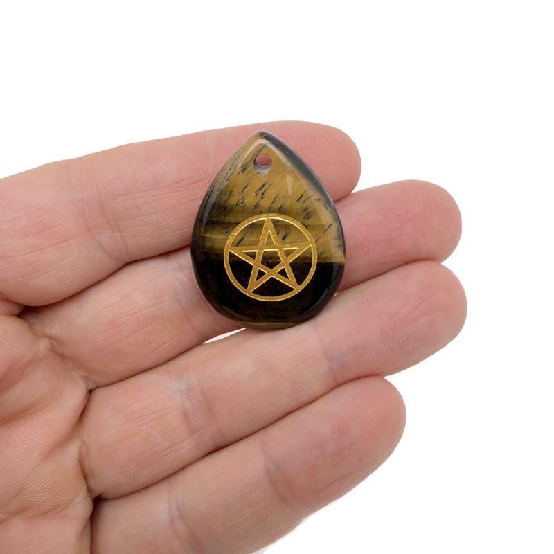 Pentagram engraved crystal from GemstoneGO, drilled for Pagan protection and balance, showcasing intricate engraving and clear crystal clarity.