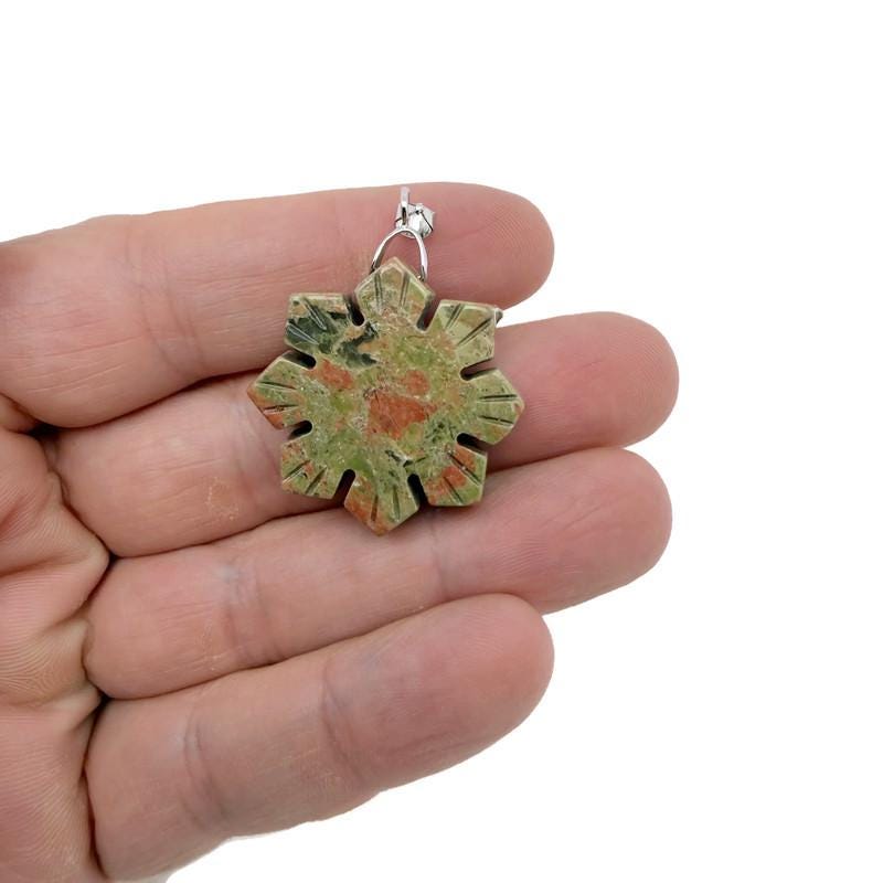 Snowflake gemstone pendant featuring a healing stone design from GemstoneGO, showcasing a delicate silver setting with a clear gemstone.