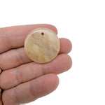 Round gemstone pendant featuring a drilled natural crystal disc charm, showcasing vibrant colors and unique gemstone patterns.