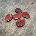 Red Jasper worry stone from GemstoneGO, 45mm smooth crystal with polished finish, used for calming and stress relief.