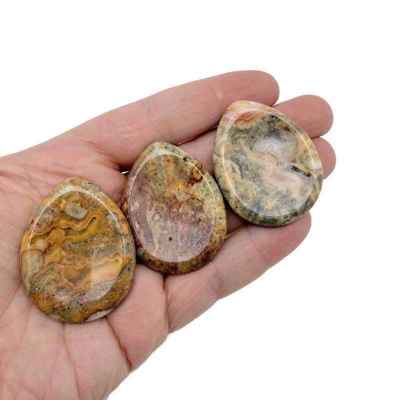 Smooth Crazy Lace Agate worry stone, 45mm, handcrafted crystal from GemstoneGO with intricate lace-like patterns for meditation and stress relief.