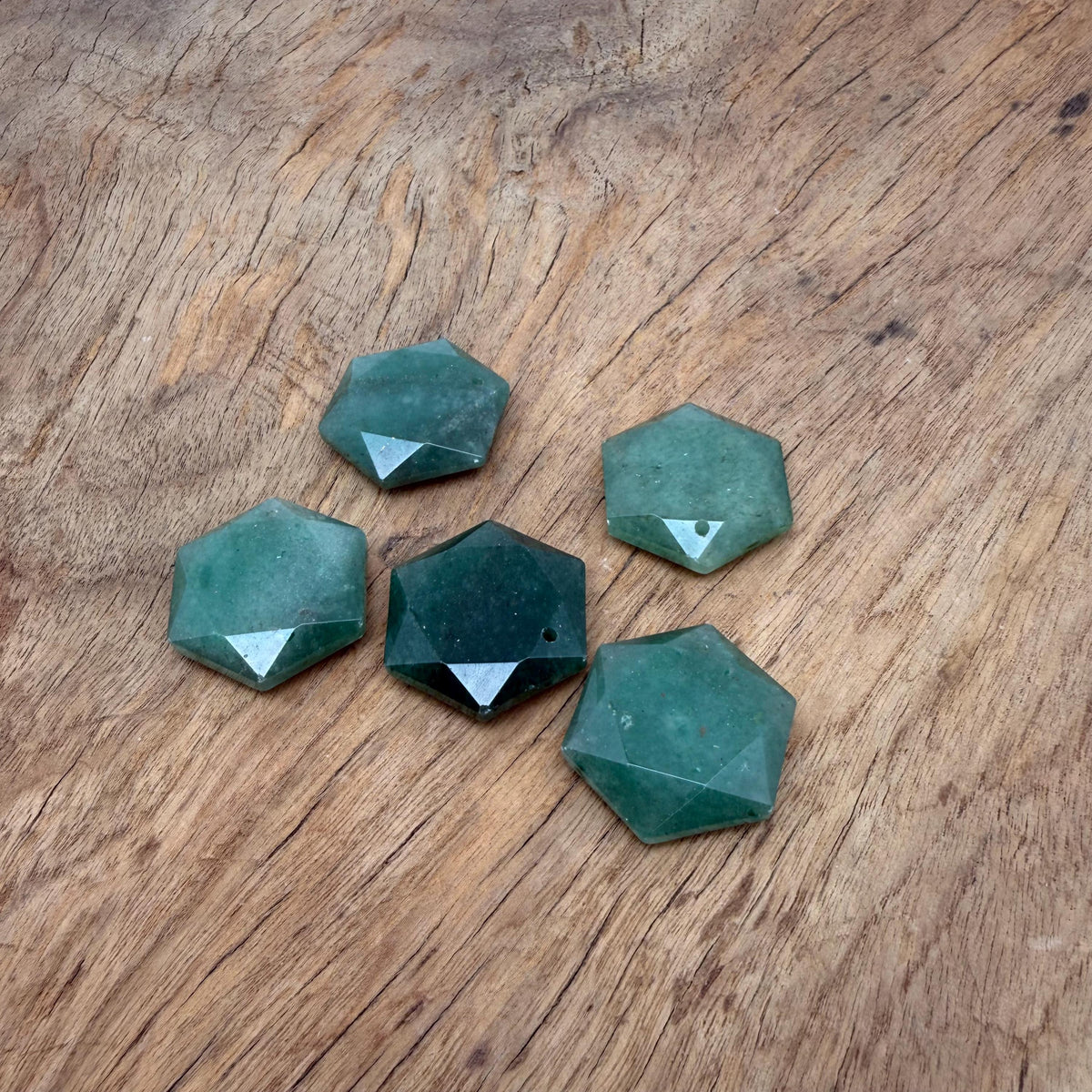 Aventurine hexagon crystal pendant with faceted surface, attached to a delicate necklace chain, showcasing natural green gemstone.