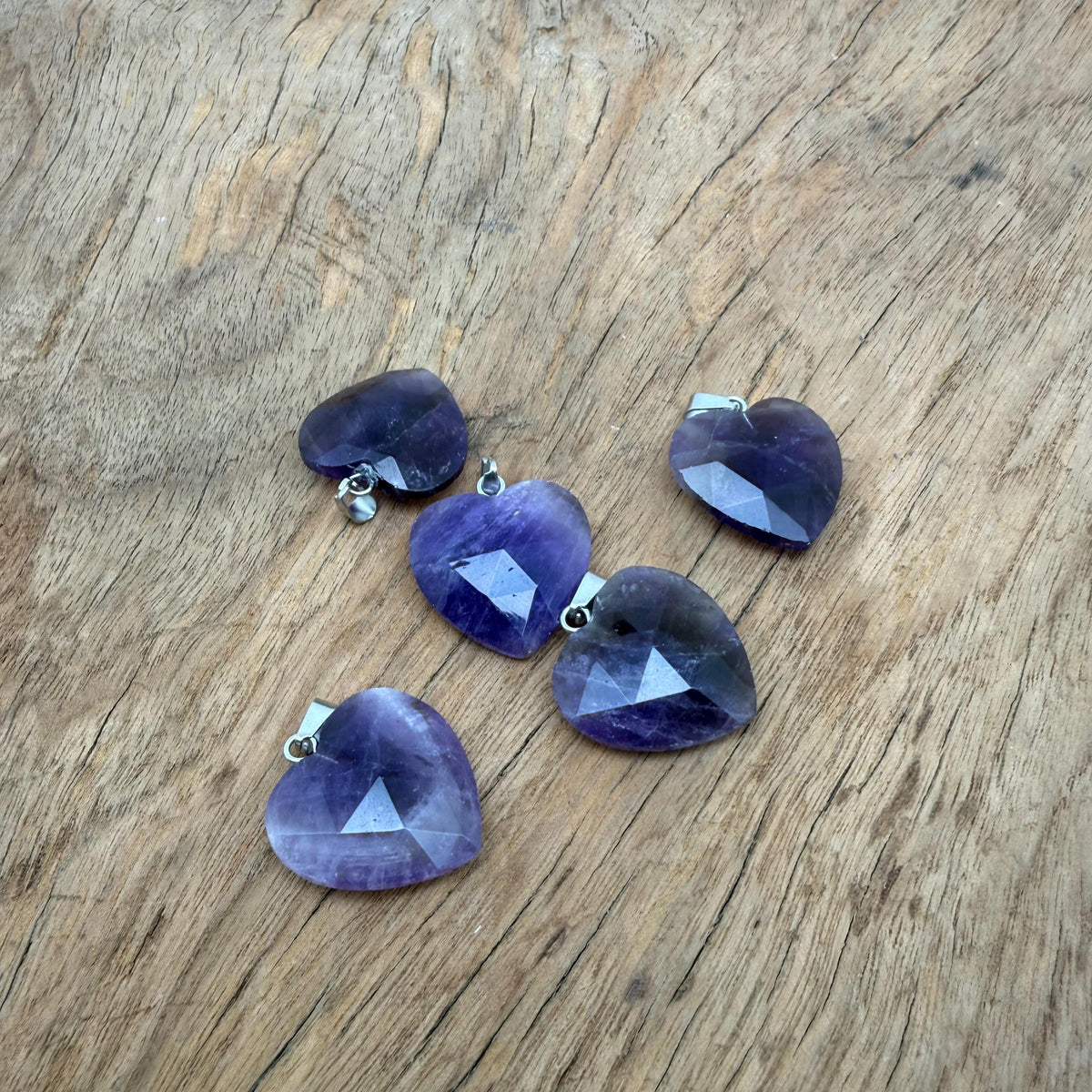 Faceted amethyst heart-shaped crystal pendant from GemstoneGO, showcasing natural purple gemstone with silver bail attachment.