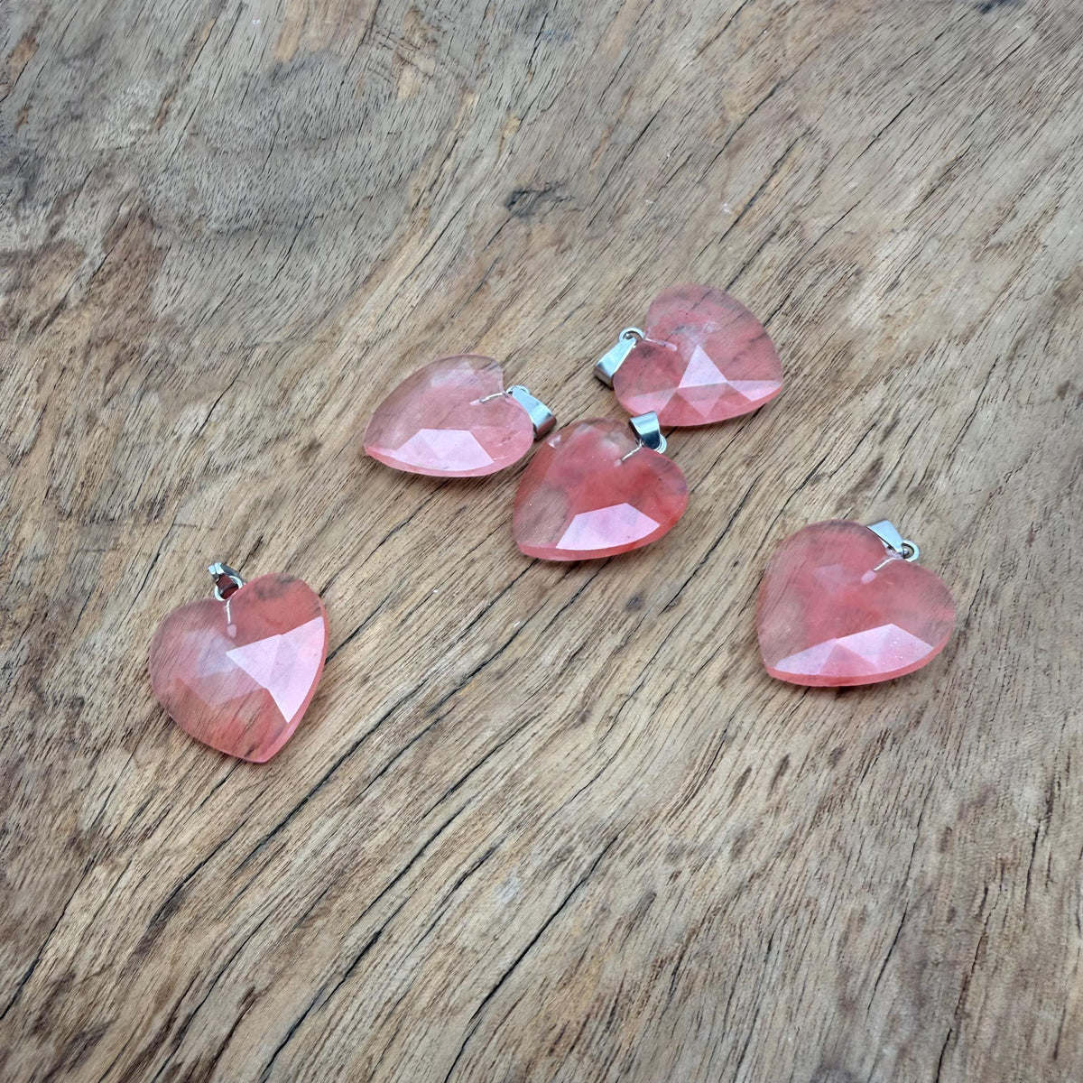 Faceted cherry quartz heart crystal pendant with natural gemstone charm, showcasing vibrant red color and polished surface.