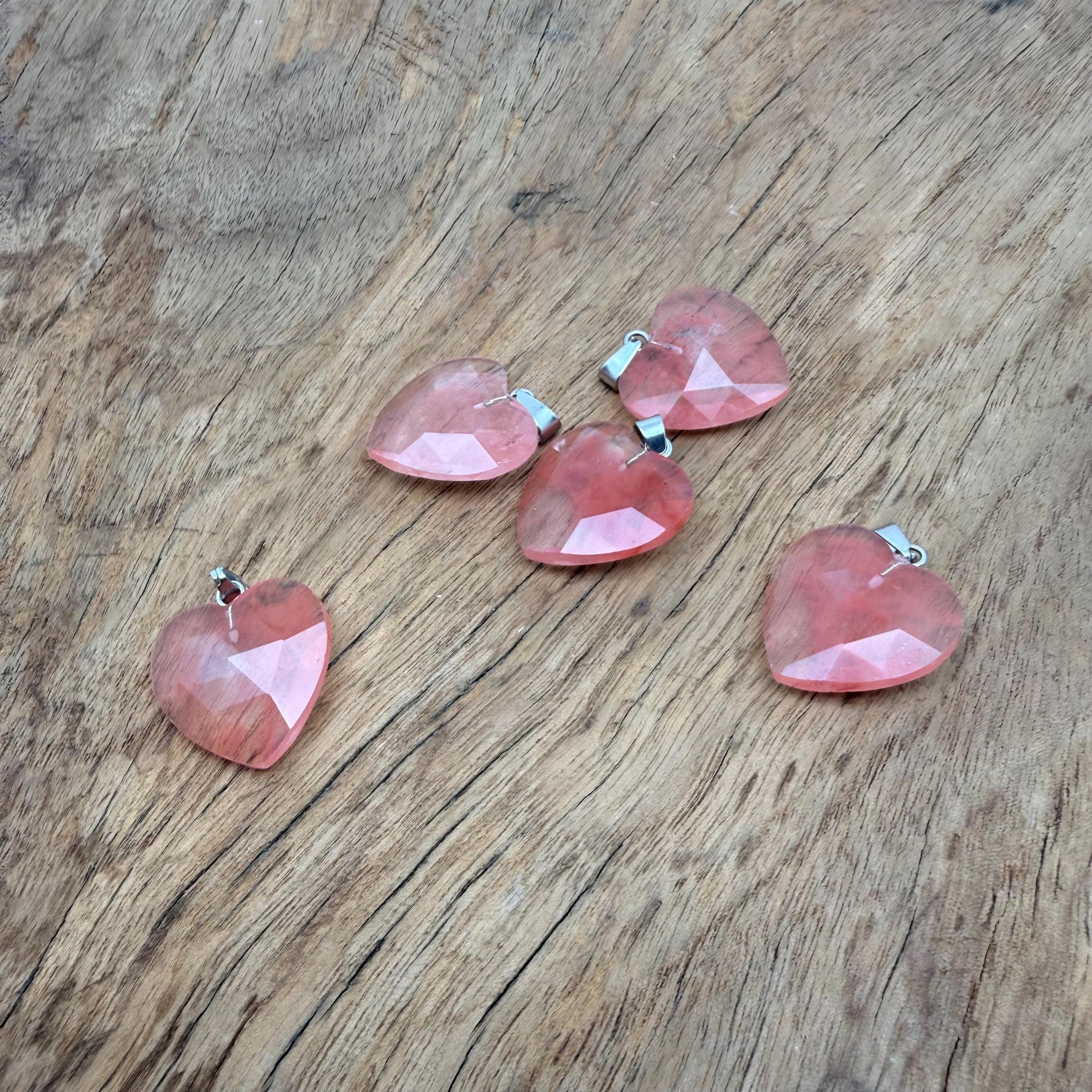 Faceted cherry quartz heart crystal pendant with natural gemstone charm, showcasing vibrant red color and polished surface.
