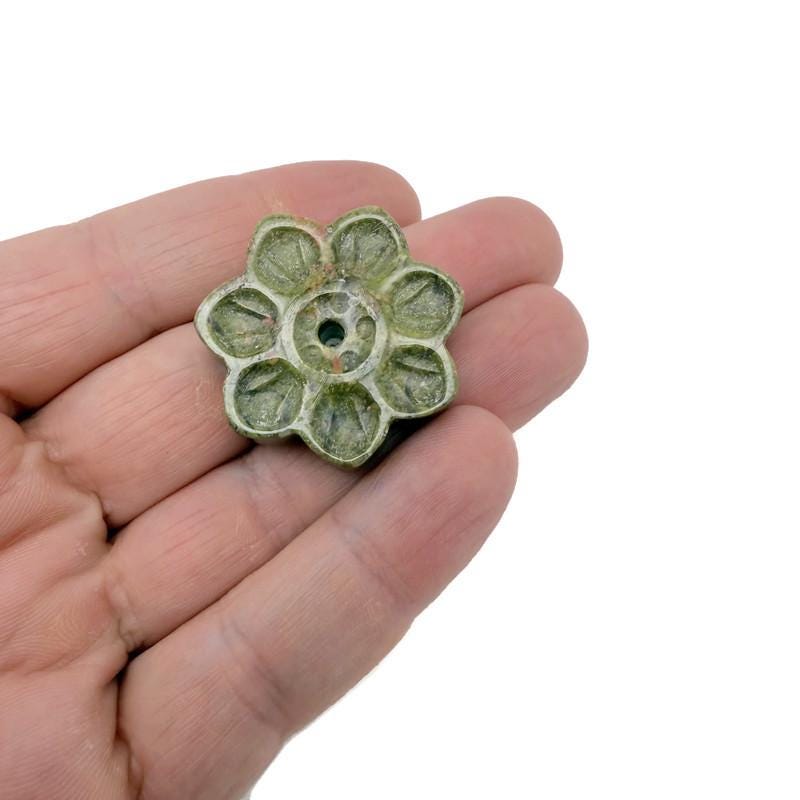 Unakite gemstone flower-shaped incense holder with carved design for stick incense, ideal for meditation and spiritual practices.