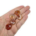 Carnelian crystal donut pendant from GemstoneGO, 20mm Pi Stone with vibrant orange-red hue and polished finish.