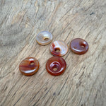 Polished 20mm carnelian crystal donut pendant with vibrant orange color and natural stone texture, from GemstoneGO.