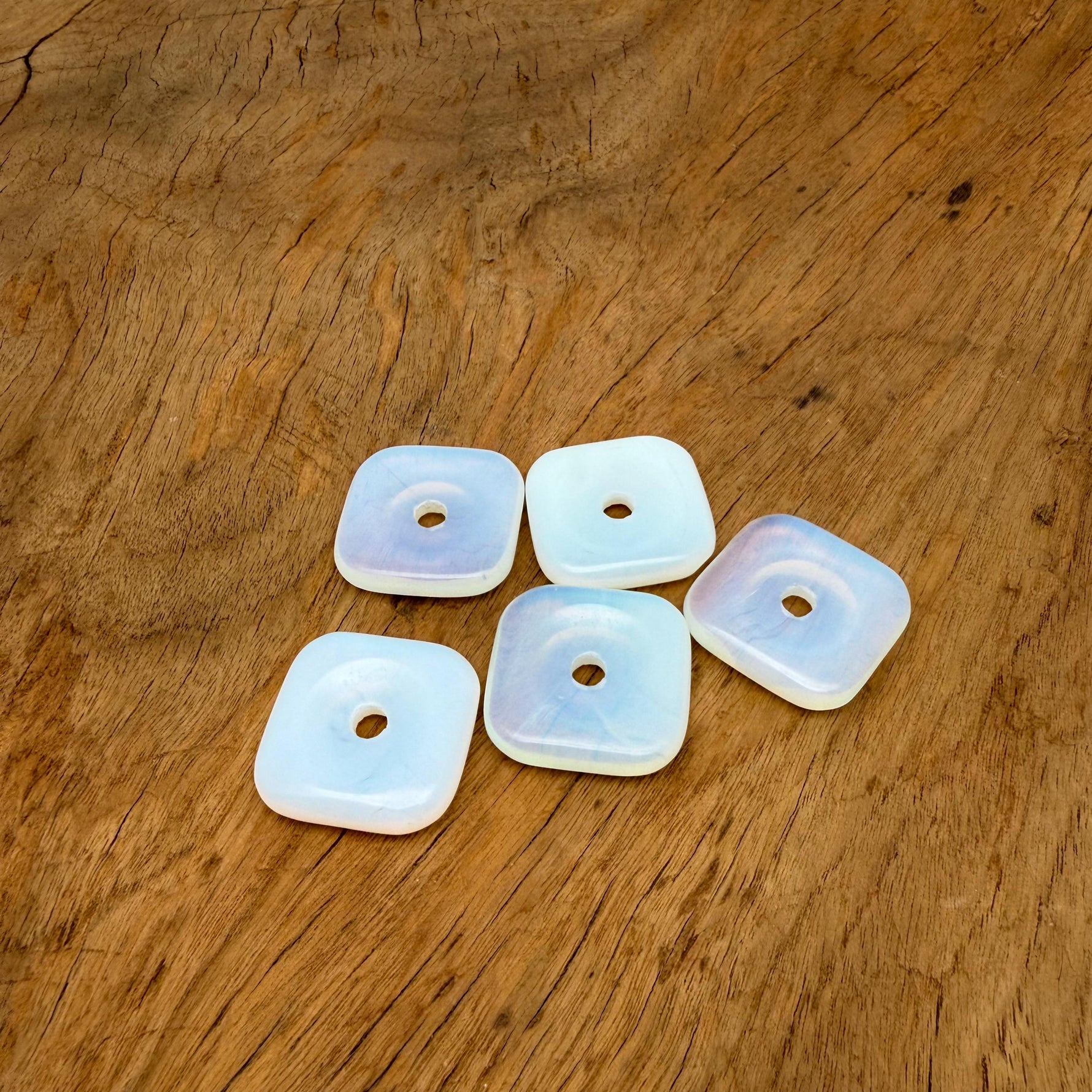 Opalite square crystal donut pendant, 30mm Pi stone from GemstoneGO, showcasing a smooth, polished gemstone with a luminous glow.