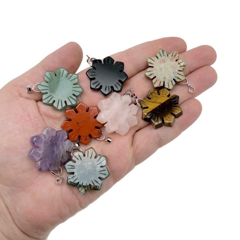 Snowflake gemstone pendant by GemstoneGO featuring a healing stone design with a silver chain and intricate snowflake pattern.