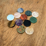 Round gemstone pendant featuring a drilled natural crystal disc charm, showcasing vibrant colors and textured surface.