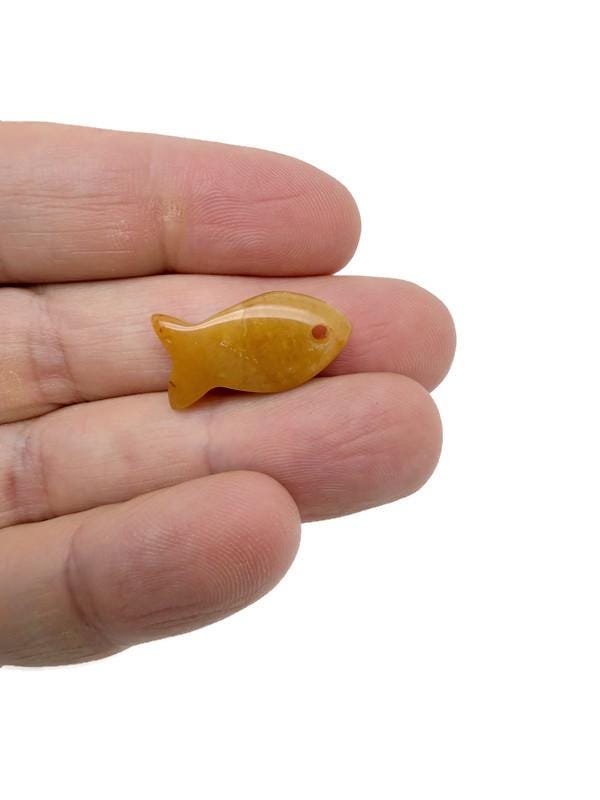 Yellow jade fish-shaped crystal pendant with a healing stone charm, perfect for jewelry and spiritual accessories.