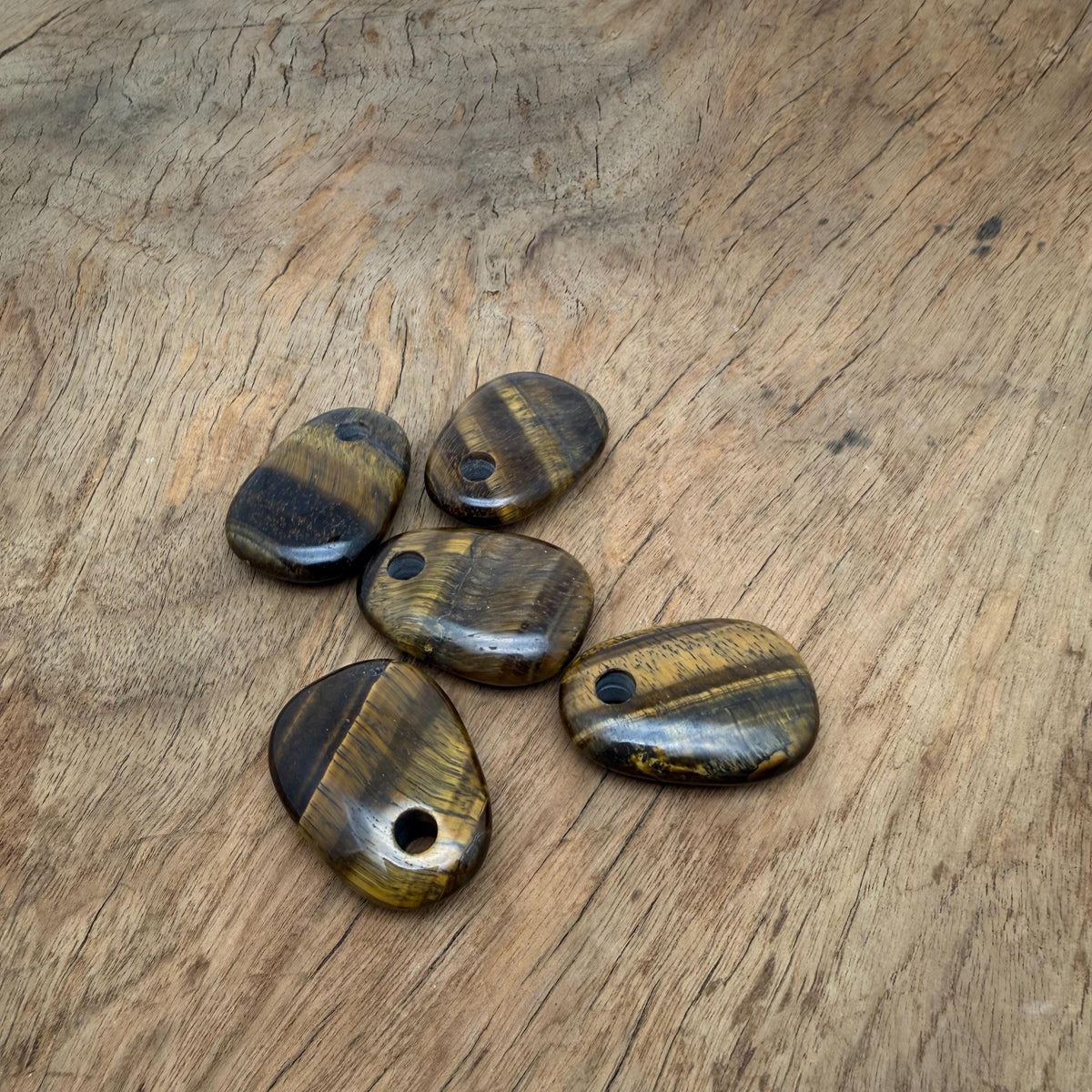 Oval Tiger Eye crystal pendant from GemstoneGO, showcasing a polished natural stone bead with warm brown and gold hues.