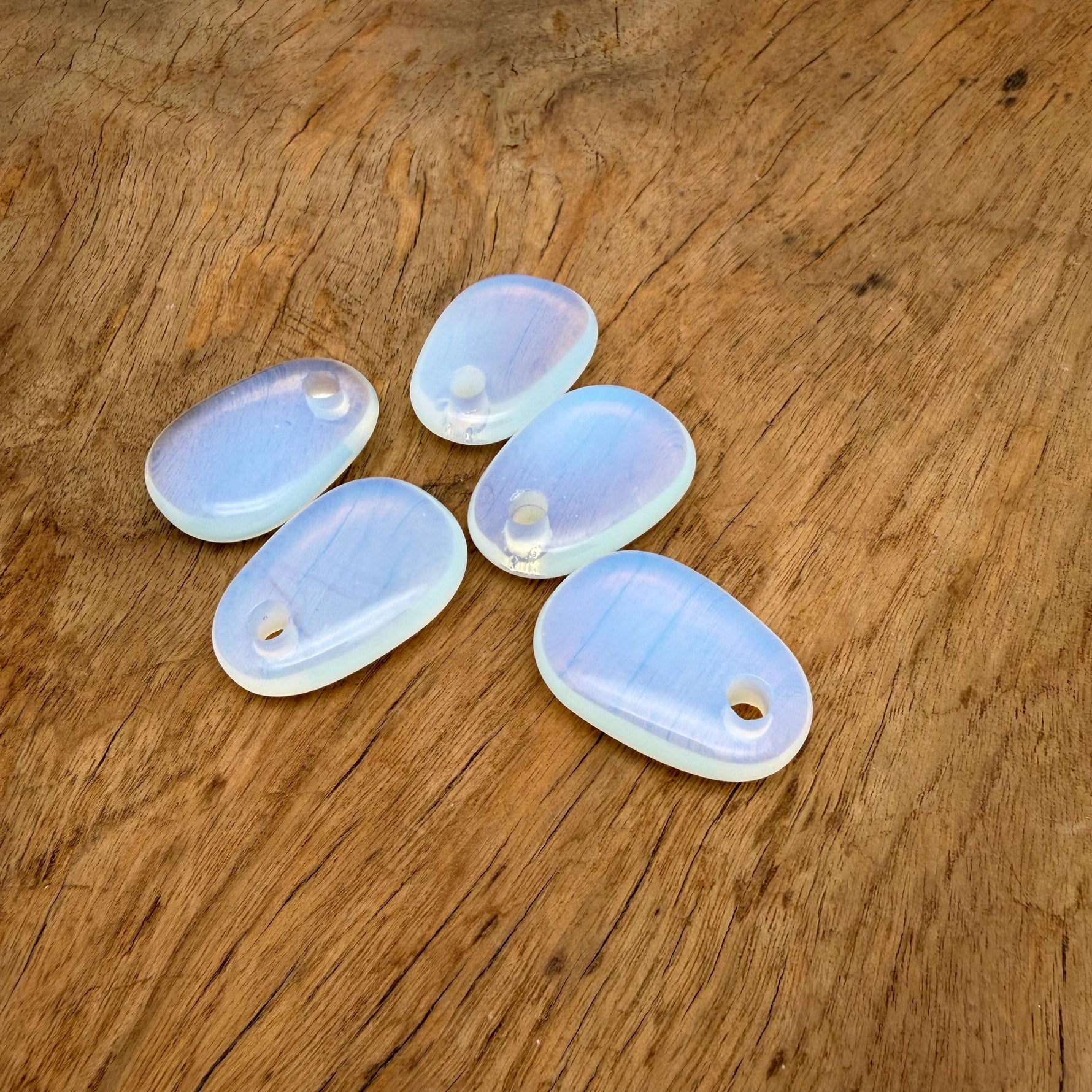 Opalite oval crystal pendant from GemstoneGO, natural stone jewelry making bead, smooth polished oval shape with subtle glow.