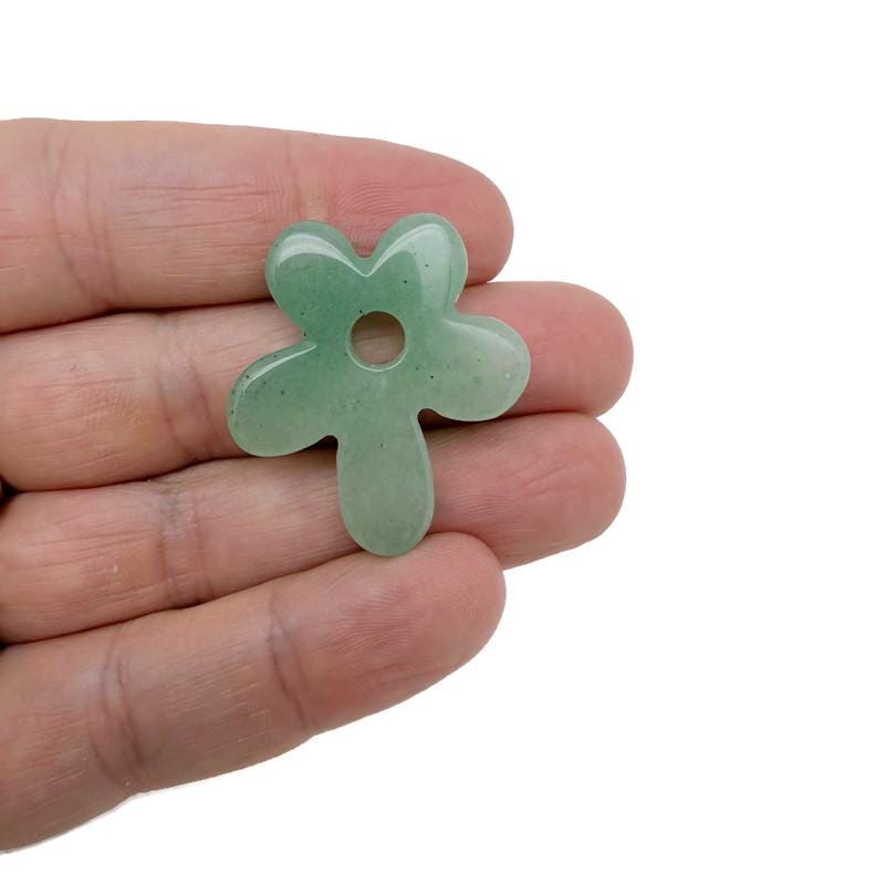 A carved aventurine gemstone pendant featuring a detailed crystal flower charm, showcasing vibrant green hues and intricate craftsmanship.