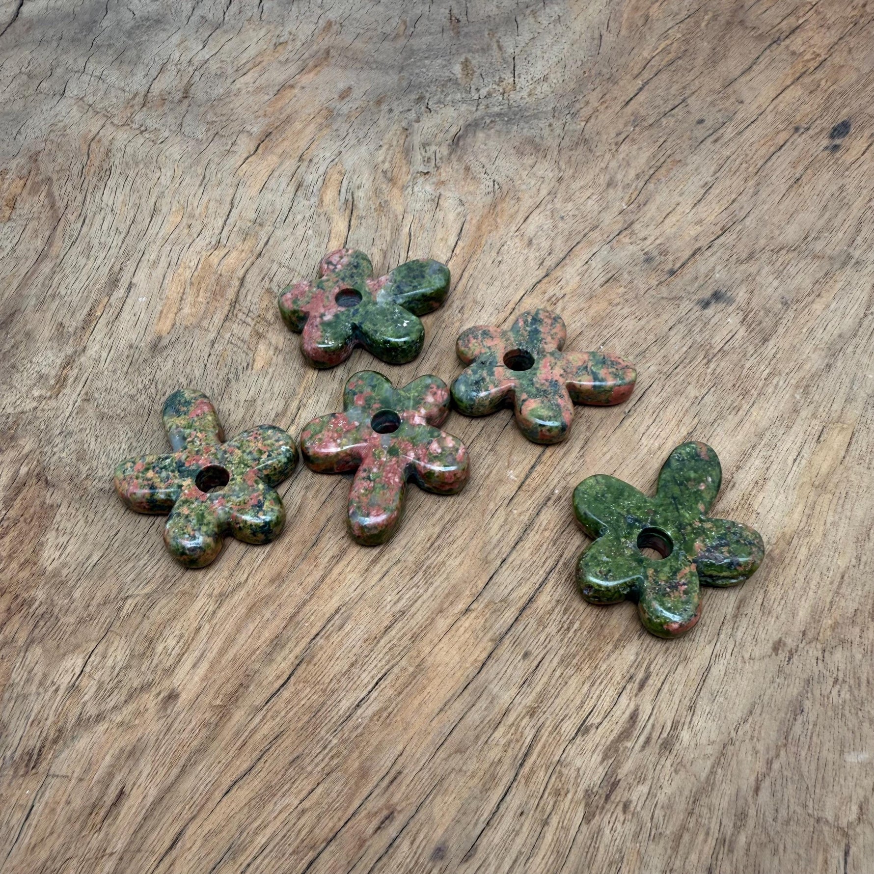 Unakite flower gemstone pendant featuring a carved crystal flower charm, showcasing vibrant colors and detailed craftsmanship.