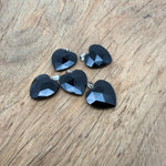 Faceted obsidian heart crystal pendant with natural gemstone charm, displayed on a silver chain. A striking gemstone jewelry piece.