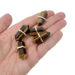 Natural tiger eye double terminated crystal pendant from GemstoneGO, showcasing a polished gemstone point with rich golden-brown hues.