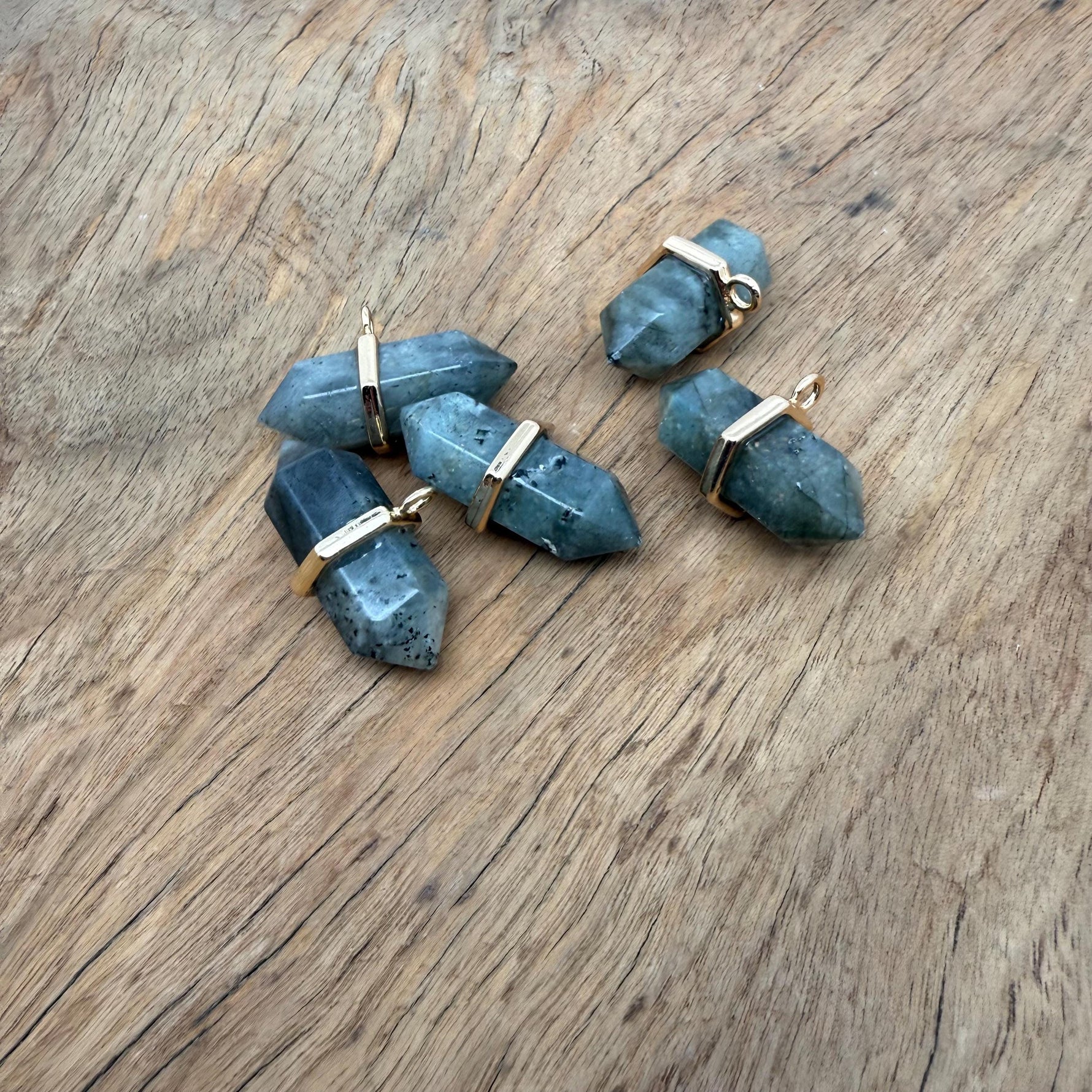 Labradorite double terminated crystal pendant with natural gemstone point, showcasing iridescent colors and polished surface.