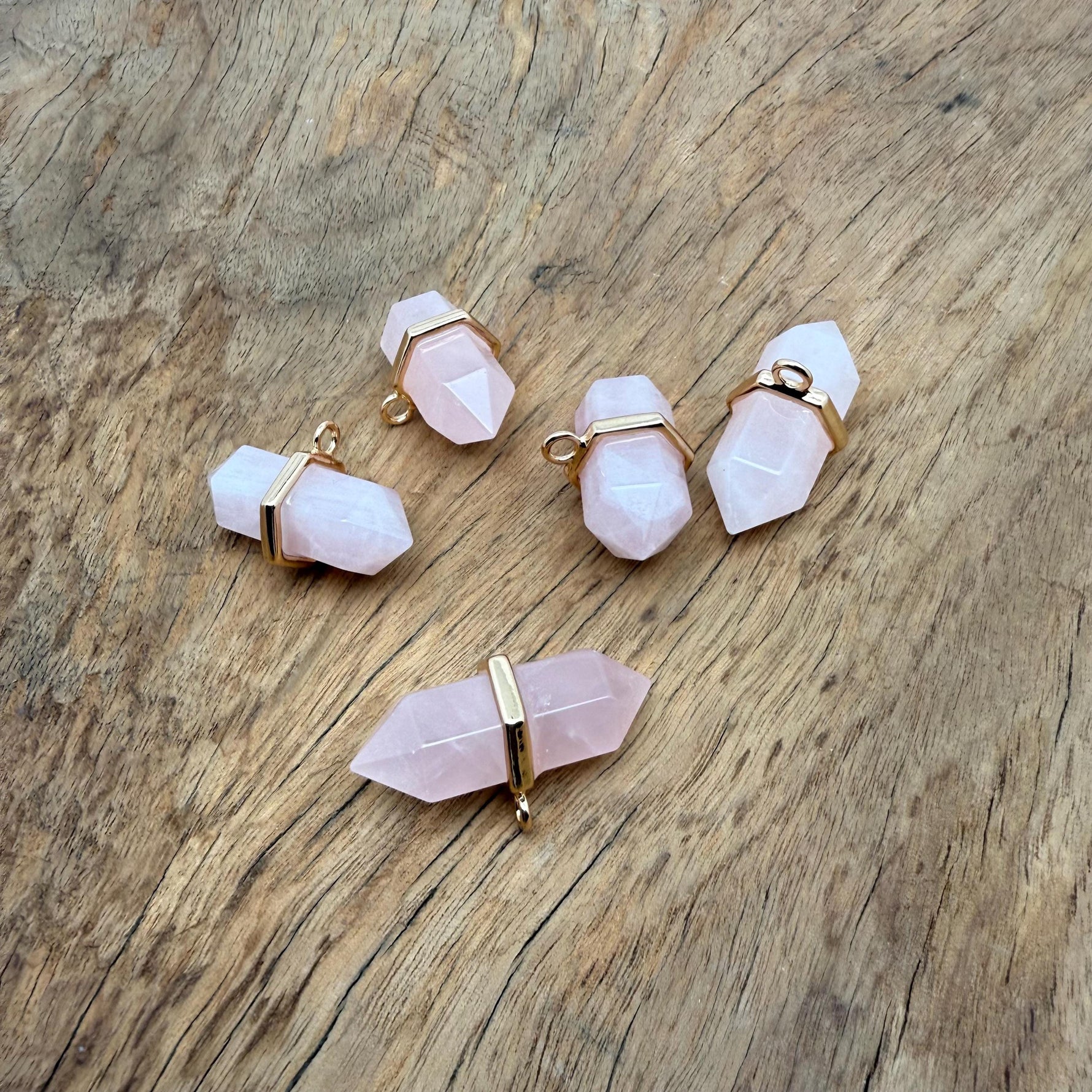 Natural rose quartz double terminated crystal pendant with a gemstone point, showcasing smooth pink gemstone and silver bail.