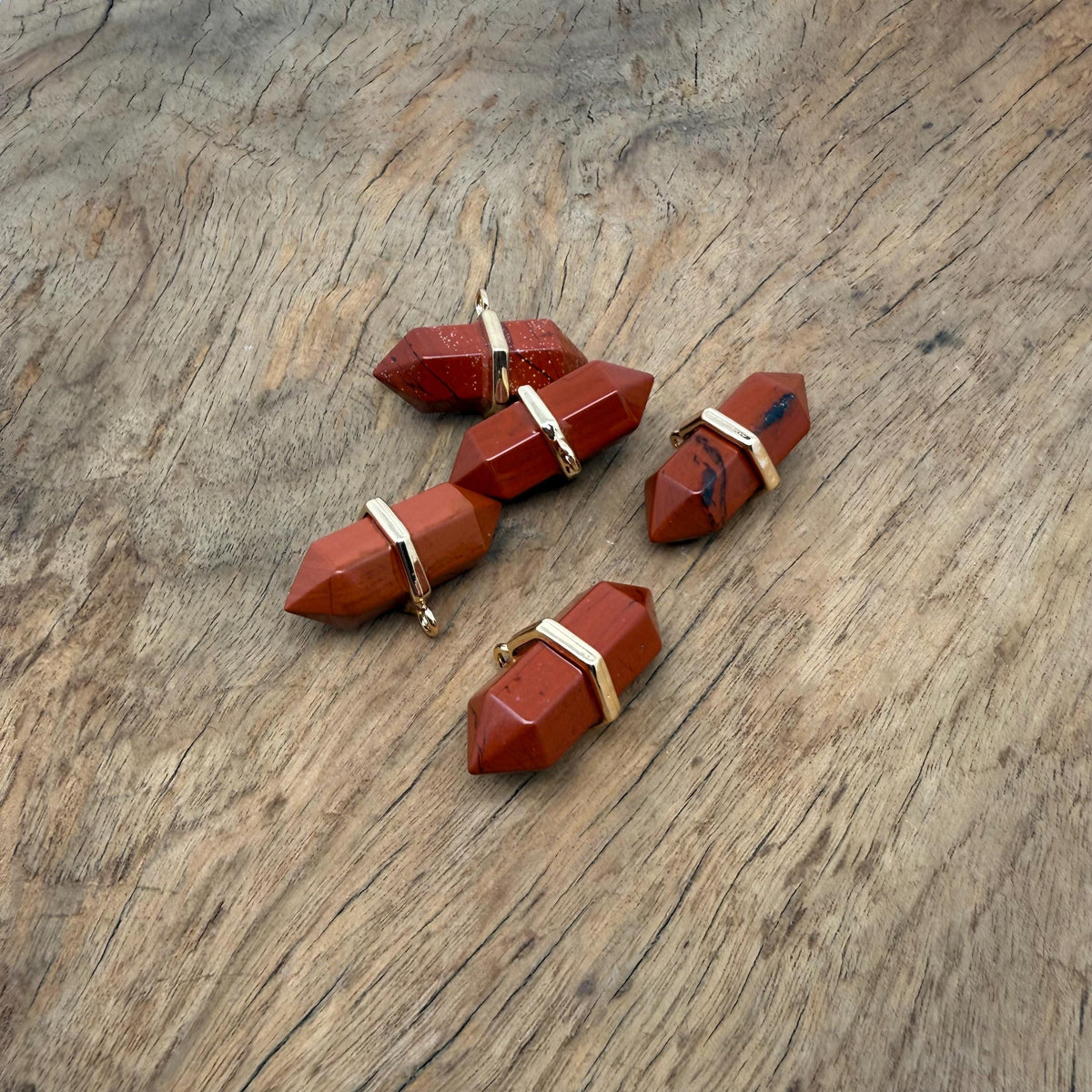 Red Jasper double terminated crystal pendant featuring a natural gemstone point with vibrant red color and unique natural markings.
